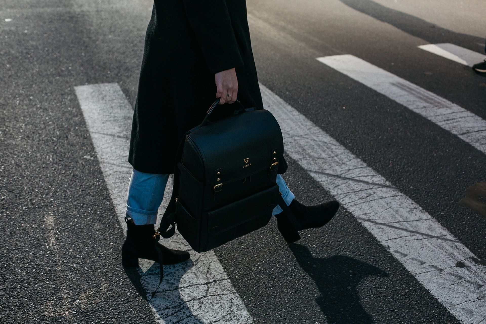 Person mit Rucksack auf einem Zebrastreifen
